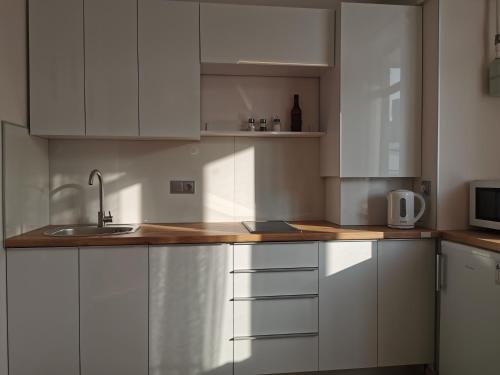 a kitchen with white cabinets and a sink at Green Apartments in Chernihiv