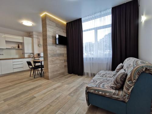 a living room with a couch and a kitchen at Green Apartments in Chernihiv