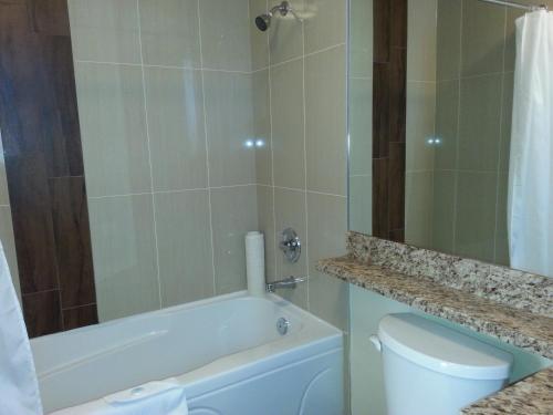 a bathroom with a tub and a toilet and a shower at Barclay Hotel in Vancouver
