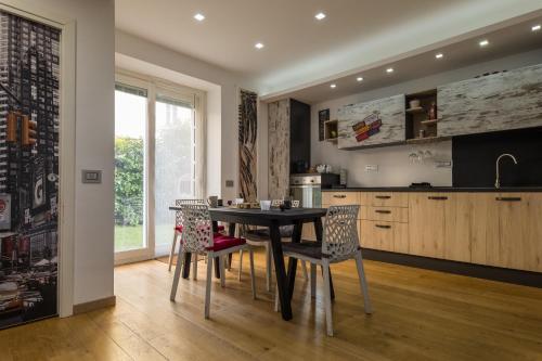 uma cozinha com uma mesa de jantar e cadeiras em Villa Capri Apartment and Room em Nápoles