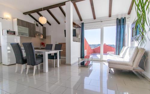 a kitchen and dining room with a table and chairs at Petra Apartment in Rab