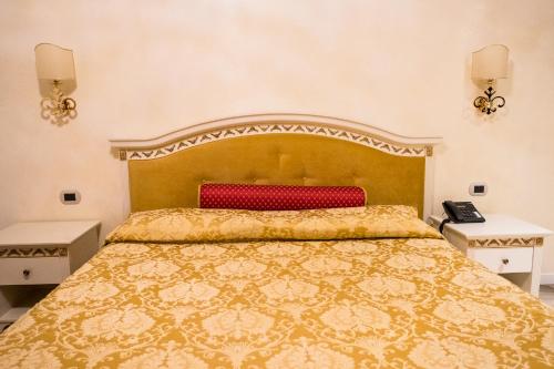 a bedroom with a large bed and two night stands at Palace Hotel & SPA La CONCHIGLIA D' ORO in Vicenza