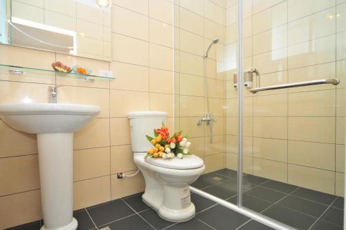 a bathroom with a toilet and a sink with flowers on it at Full Sun House - Peng's Family in Taitung City
