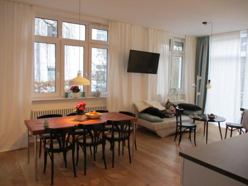 uma sala de estar com uma mesa e cadeiras e um sofá em Apartment am Apfelbaum em Reutlingen