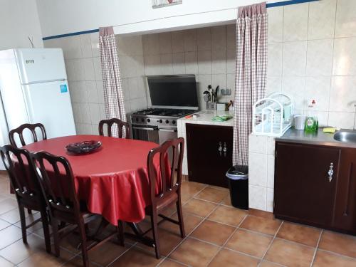 uma cozinha com uma mesa vermelha e cadeiras num quarto em Casa da Tia Marina em Lajes das Flores