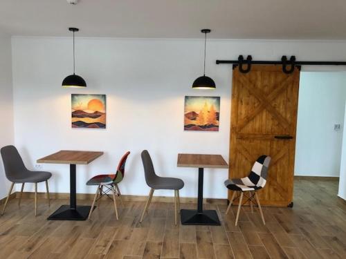 a group of tables and chairs in a room at ALPIN rooms in Topliţa