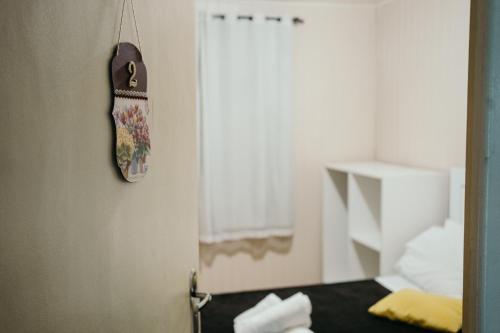 eine Tür zu einem Schlafzimmer mit einem Bett und einer Uhr an der Wand in der Unterkunft Pousada Recanto da Serra - Unidade Campestre in Urubici