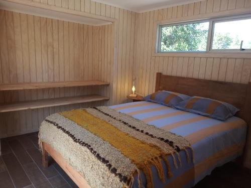 1 dormitorio con cama y ventana en Cabañas Truful Truful, en Melipeuco