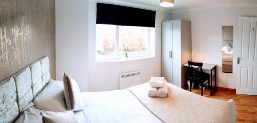 a bedroom with a white bed and a window at Brookview 2BR Flat Oxford City Centre Free Parking in Oxford