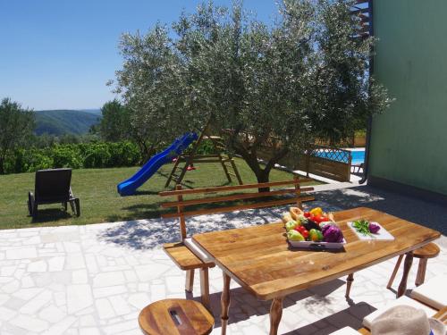 Gorica的住宿－Spacious apartment with views of the vineyards，一张桌子,上面放着一碗水果,还有一个游乐场