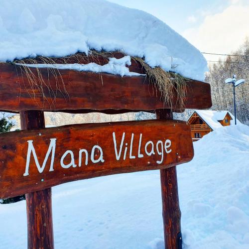 a sign that says manano village in the snow at Mana Village - Jacuzzi & Sauna in Barłomino