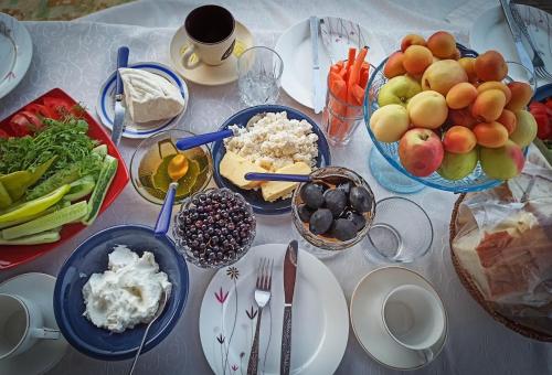 a table with plates of food and bowls of fruit at Khachats Toun Heritage in Meghri