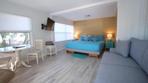 a bedroom with a bed and a table and a couch at BeachPoint Cottages in Siesta Key