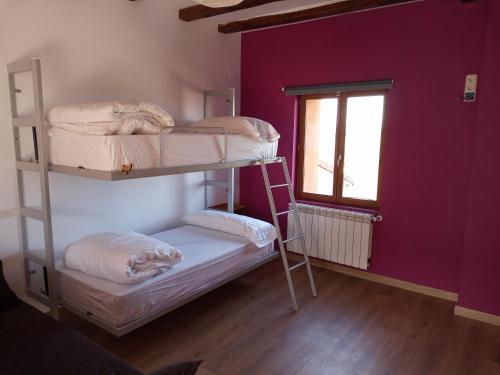 two bunk beds in a room with a window at Albergue Fresno de Cantespino - La Tormenta in Fresno de Cantespino