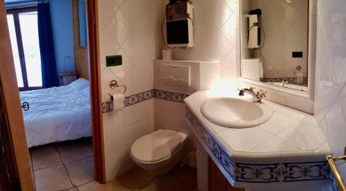 a bathroom with a sink and a toilet and a bed at Chalet Rivière, 5 en-suite. in La Salle Les Alpes