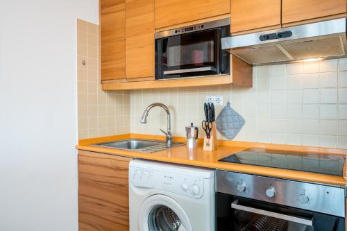 a kitchen with a sink and a washing machine at *AlgarvianStudio-Vilamoura City Centre* in Vilamoura