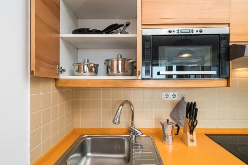 a kitchen with a sink and a microwave at *AlgarvianStudio-Vilamoura City Centre* in Vilamoura