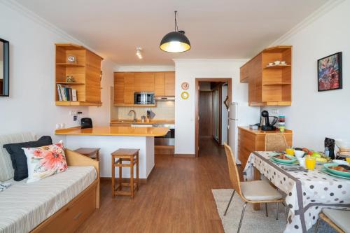 a living room and kitchen with a couch and a table at *AlgarvianStudio-Vilamoura City Centre* in Vilamoura