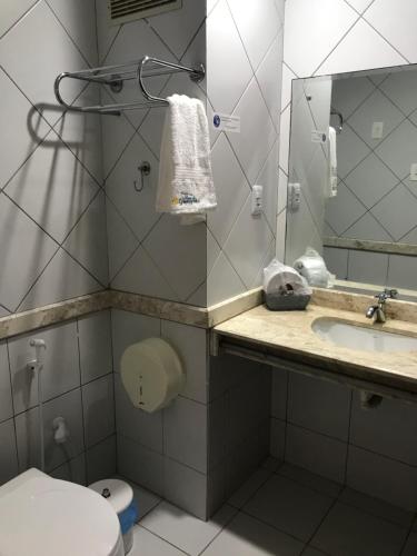 La salle de bains est pourvue de toilettes, d'un lavabo et d'un miroir. dans l'établissement Pousada Praia De Guarajuba, à Guarajuba
