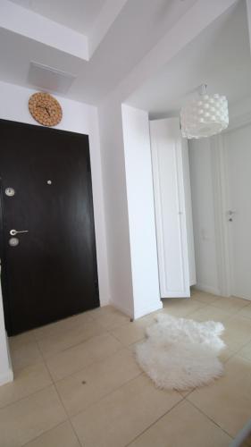 a room with a black door and a white rug at Casa Bella in Ştefăneştii de Jos