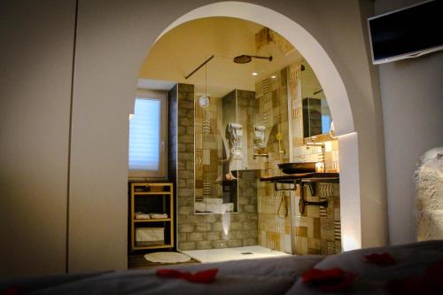uma casa de banho com um chuveiro e um espelho grande em La Casupola em Monopoli