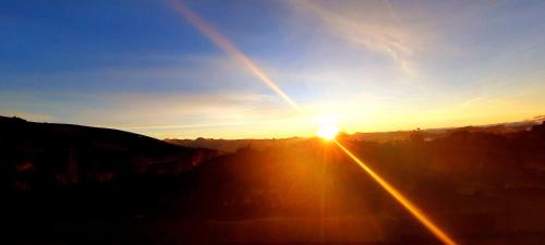 a sunset with the sun setting in the sky at Hotel Imperial Zumbahua & Quilotoa Lodge in Zumbahua