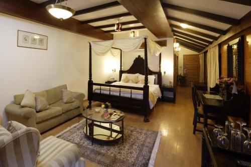 a living room with a bed and a couch and a table at Manuallaya The Resort & Spa in Manāli
