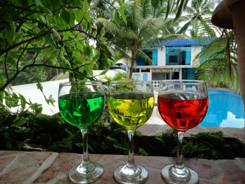 three glasses of wine sitting on a table at Hotel La Cascada - Lago Agrio in Nueva Loja