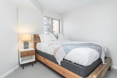 ein Schlafzimmer mit einem großen Bett und einem Fenster in der Unterkunft Tyndall Stone by Outpost Whistler in Whistler