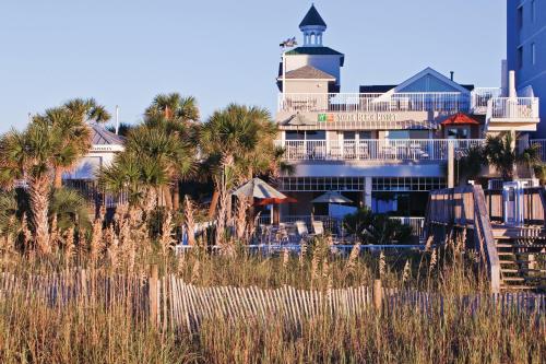 a resort with palm trees in front of a building at Holiday Inn Club Vacations South Beach Resort in Myrtle Beach
