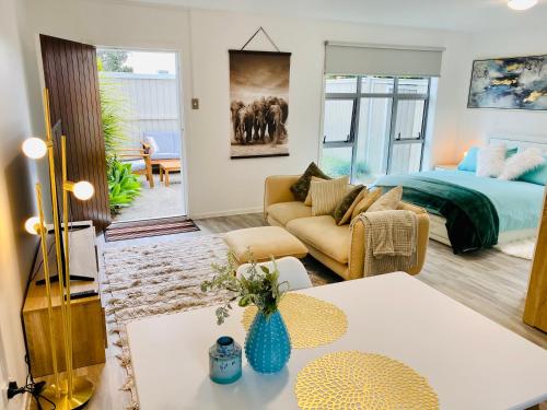a living room with a bed and a couch at Takapuna Guest House in Auckland