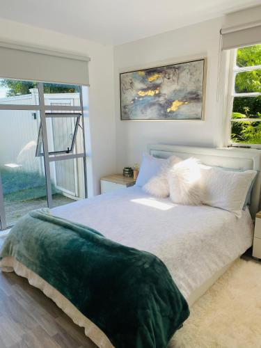 a bedroom with a large bed with a large window at Takapuna Guest House in Auckland