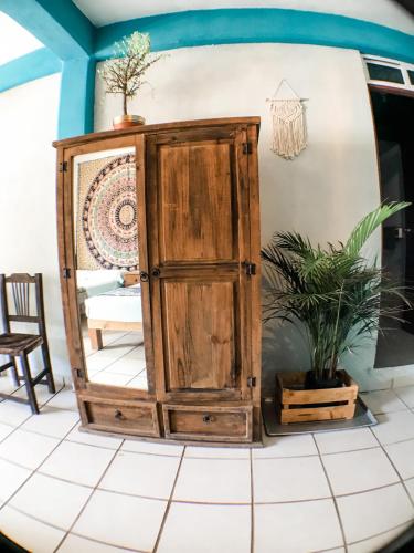 an old wooden cabinet in a room with a potted plant at Colibri Hotel in Cabo Corrientes