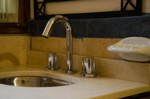 a sink with a faucet in a bathroom at Munay Salta in Salta
