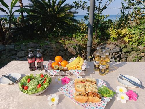 a table with a bunch of food and drinks on it at Maribu Beach House in Yamada