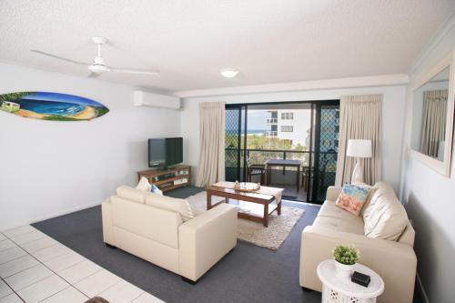 a living room with two couches and a tv at San Marino by the Sea Apartments in Marcoola