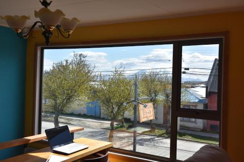 a laptop sitting on a table in front of a window at Asói Hostal in Puerto Natales