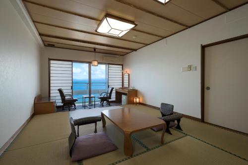 sala de estar con mesa y sillas en Ibusuki Kaijo Hotel, en Ibusuki