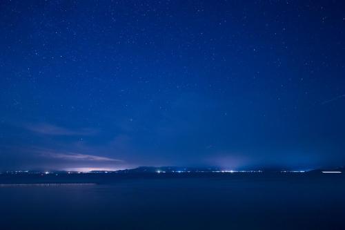 a night view of a lake with a starry sky at Ibusuki Kaijo Hotel in Ibusuki