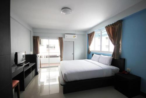1 dormitorio con 1 cama blanca grande y TV en DD Residence en Rayong