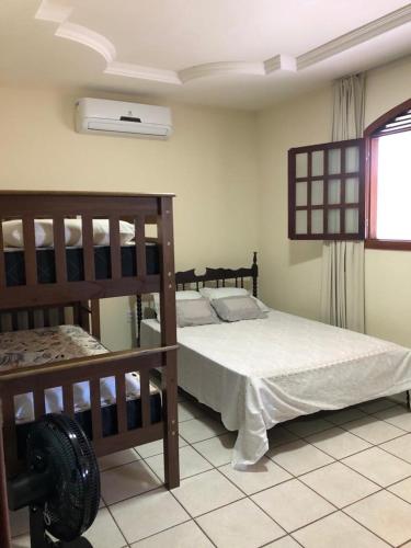 a bedroom with two bunk beds and a window at casa em Barra de Cunhaú-RN in Barra do Cunhau
