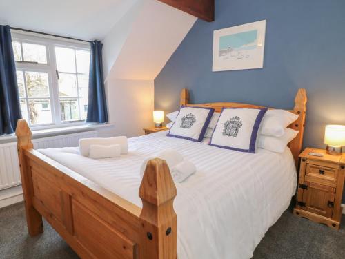a bedroom with a wooden bed and a window at Thatchings in Bude