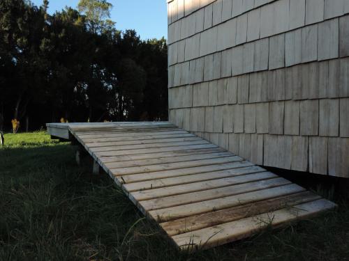 a wooden ramp on the side of a building at Cabañas Arrayanes de Huillinco en Chiloé in Chonchi