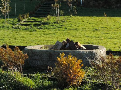 a fire pit in the middle of a field at Cabañas Arrayanes de Huillinco en Chiloé in Chonchi