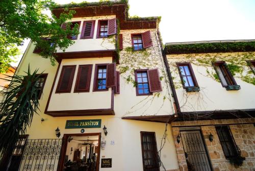 an old building with brown shutters on it at Sibel Hotel in Antalya