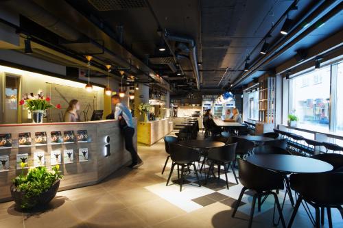 a restaurant with tables and chairs and a bar at Comfort Hotel City in Gothenburg