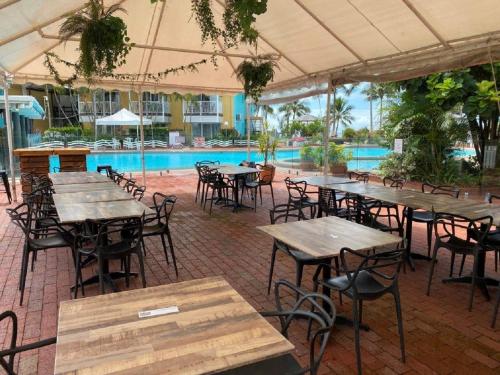 a patio area with tables, chairs and umbrellas at The Resort at Dolphin Heads in Mackay