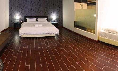 a bedroom with a bed and a wooden floor at Putatan Platinum Hotel in Kota Kinabalu