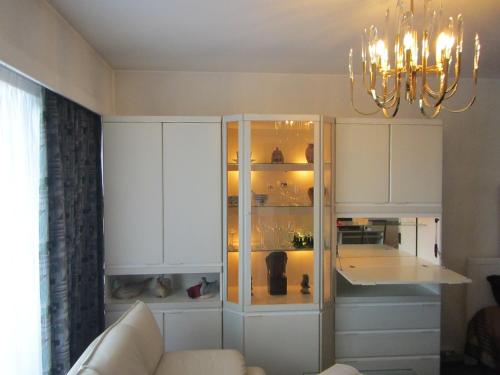 una cocina con armarios blancos y una lámpara de araña en - - - - - Au Sixième Ciel - - - - -, en Bruselas