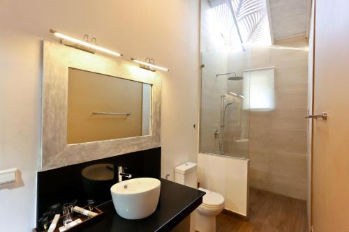 a bathroom with a sink and a shower at Swanee Grand in Negombo
